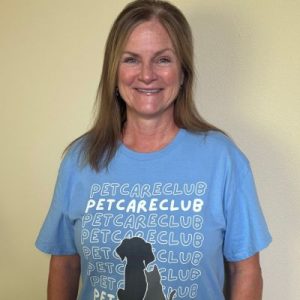 Pet care professional Paige smiling at the camera while wearing a blue Pet Care Club shirt.